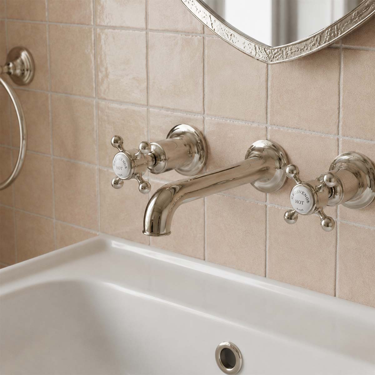 Brushed nickel wall-mounted bathroom tap set with two cross handles and a curved spout