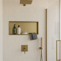 Gold bathroom shower niche with a rectangular framed shelf