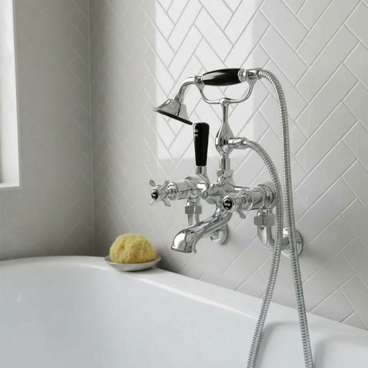 chrome bathtub tap set with a handheld shower hose, mounted on a white tiled wall 1200