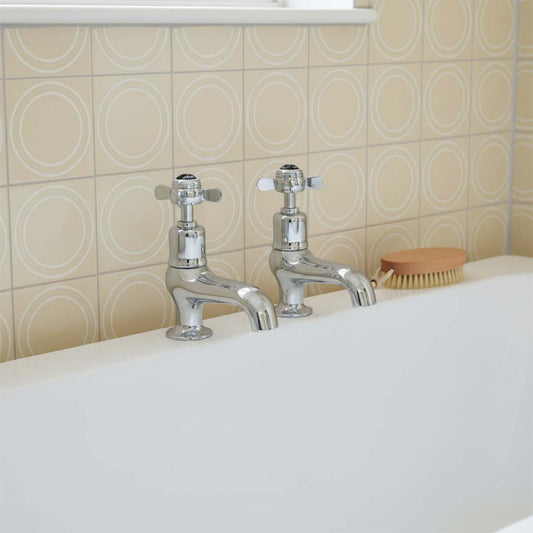 polished chrome bathroom pillar taps mounted on a white bathtub 1200
