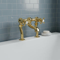 Traditional polished gold bridge bath tap with two white cross handles