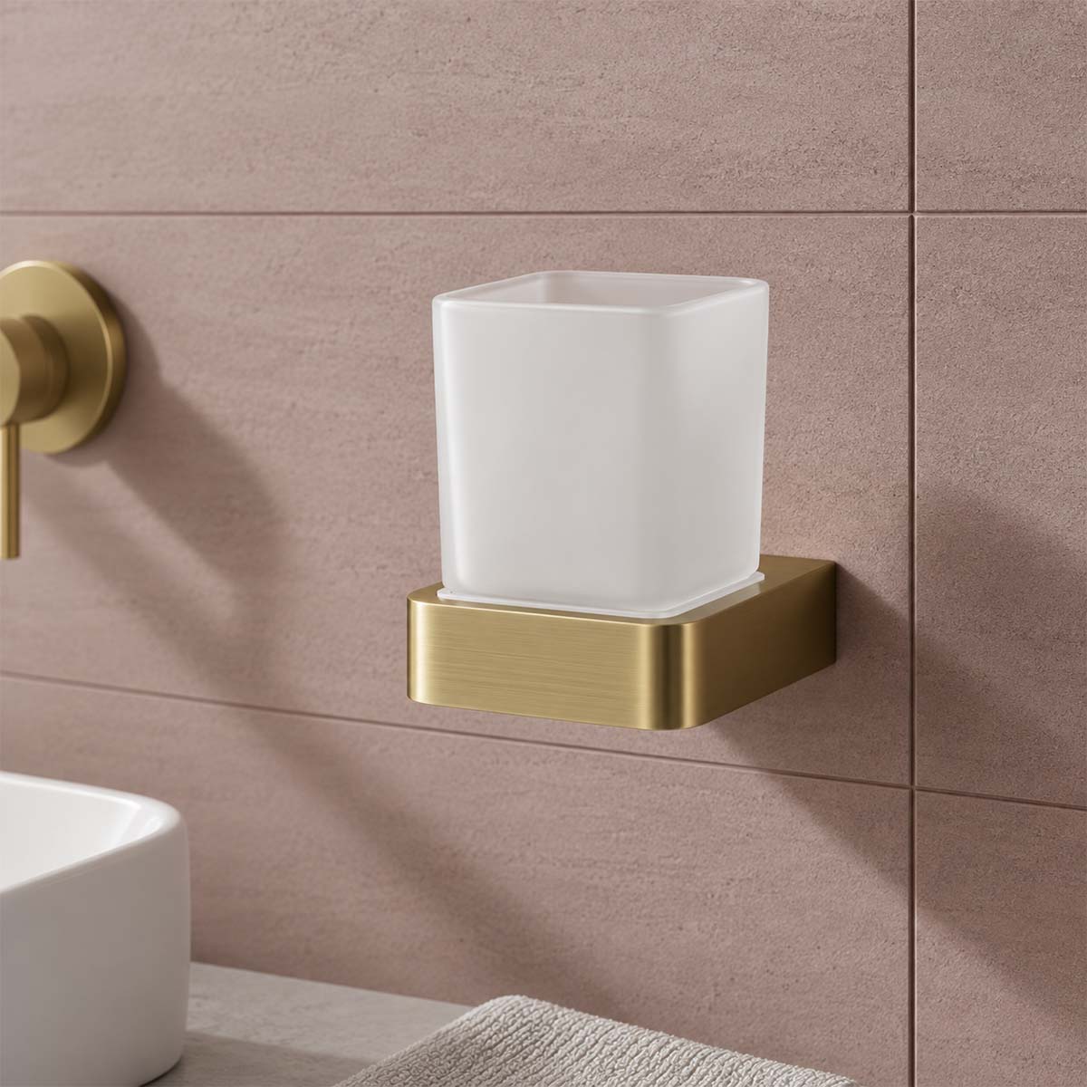 wall-mounted bathroom cup holder with a frosted white square cup on a brushed gold bracket